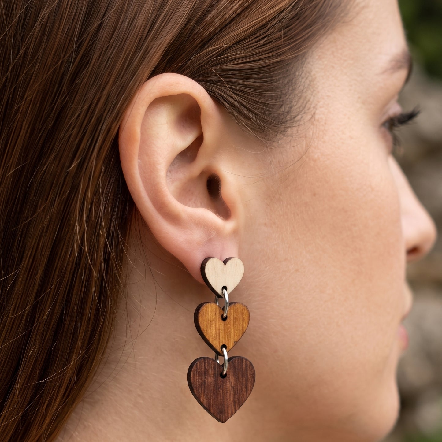Woman wearing three-tier ombre wooden heart dangle earrings, handmade jewelry by Mekala Crafts