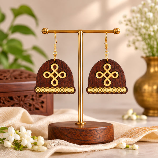 Dome-shaped wooden dangle earrings with gold kolam knot design and beaded trim, displayed on jewelry stand by Mekala Crafts
