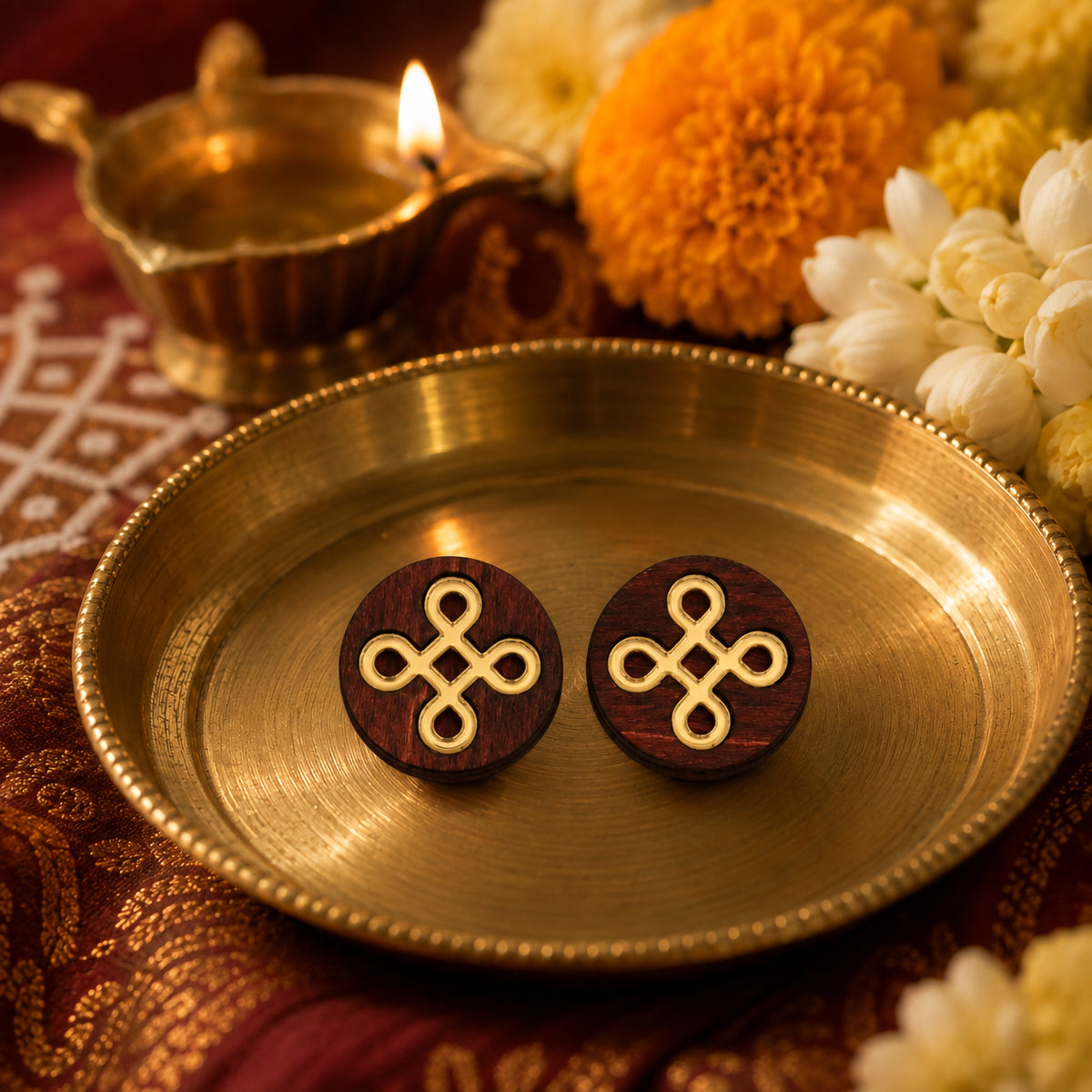 Round wooden kolam knot stud earrings with gold inlay displayed on brass plate with festive flowers, handmade by Mekala Crafts