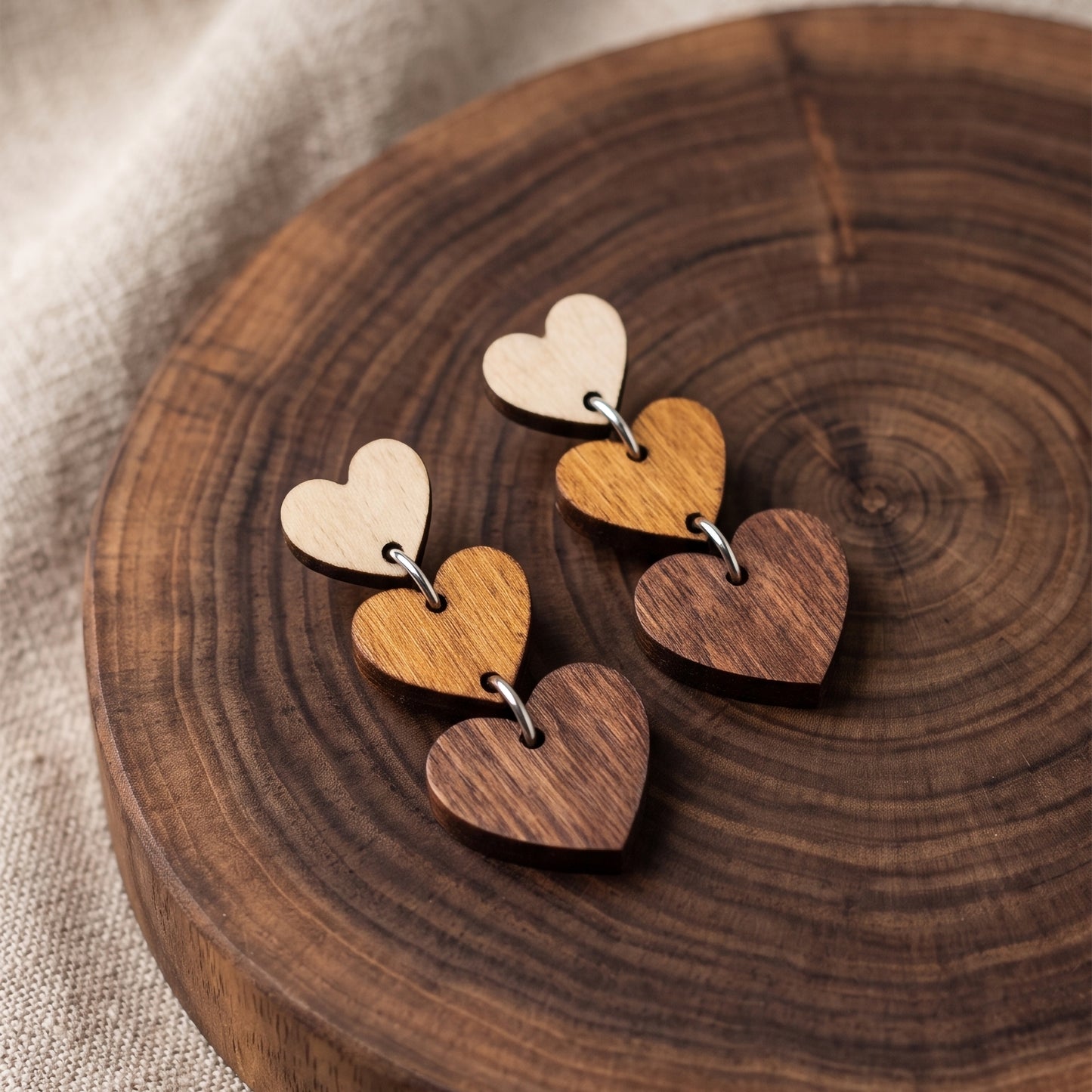 Three-tier ombre wooden heart dangle earrings in natural wood tones, handmade by Mekala Crafts