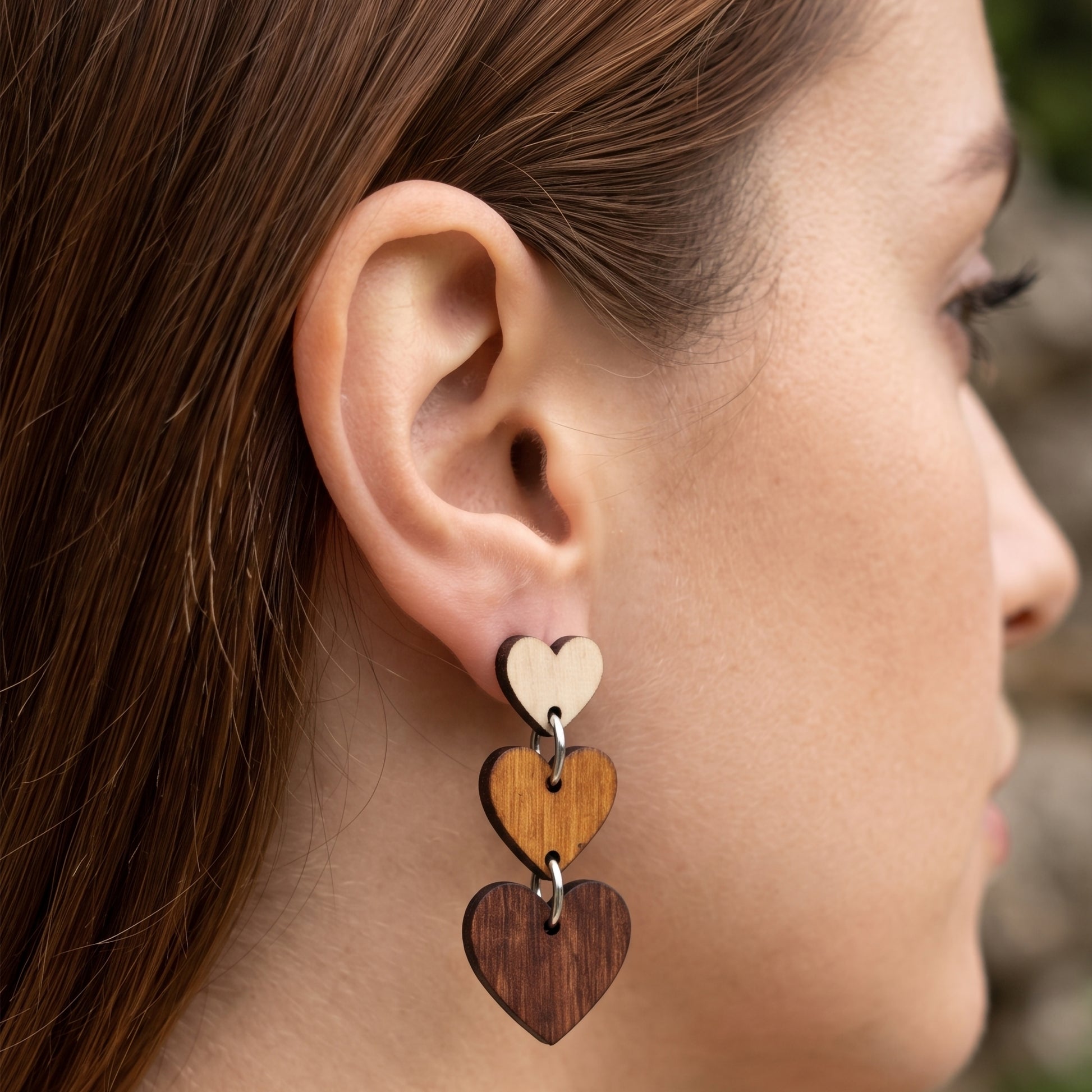 Woman wearing three-tier ombre wooden heart dangle earrings, handmade jewelry by Mekala Crafts