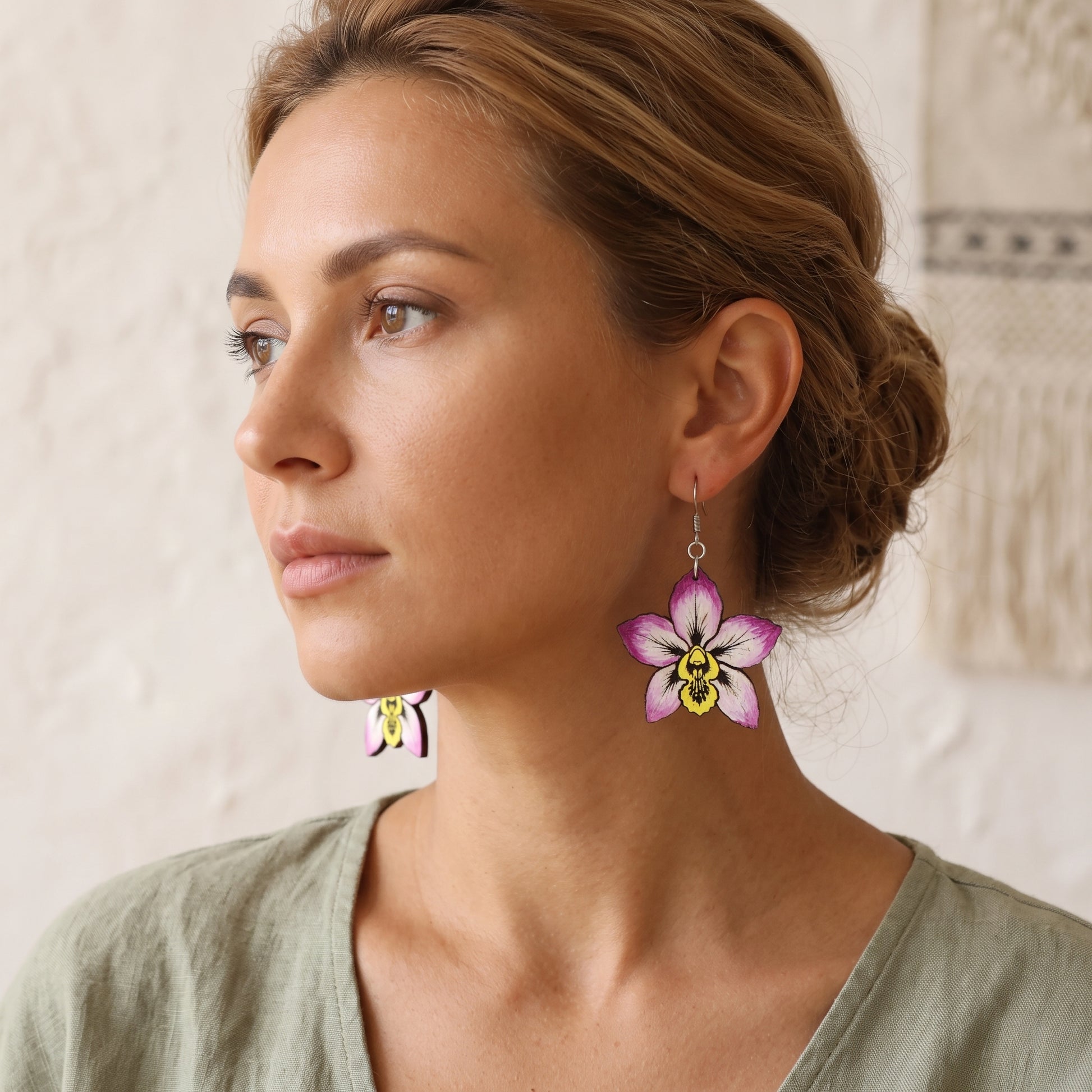 Woman wearing purple orchid flower wooden dangle earrings, handmade jewelry by Mekala Crafts