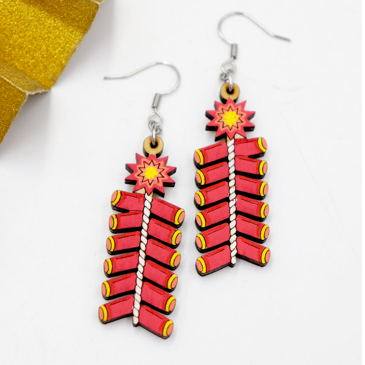 Hand-painted wooden Diwali red firecracker string dangle earrings with white fuse and starburst, handmade by Mekala Crafts