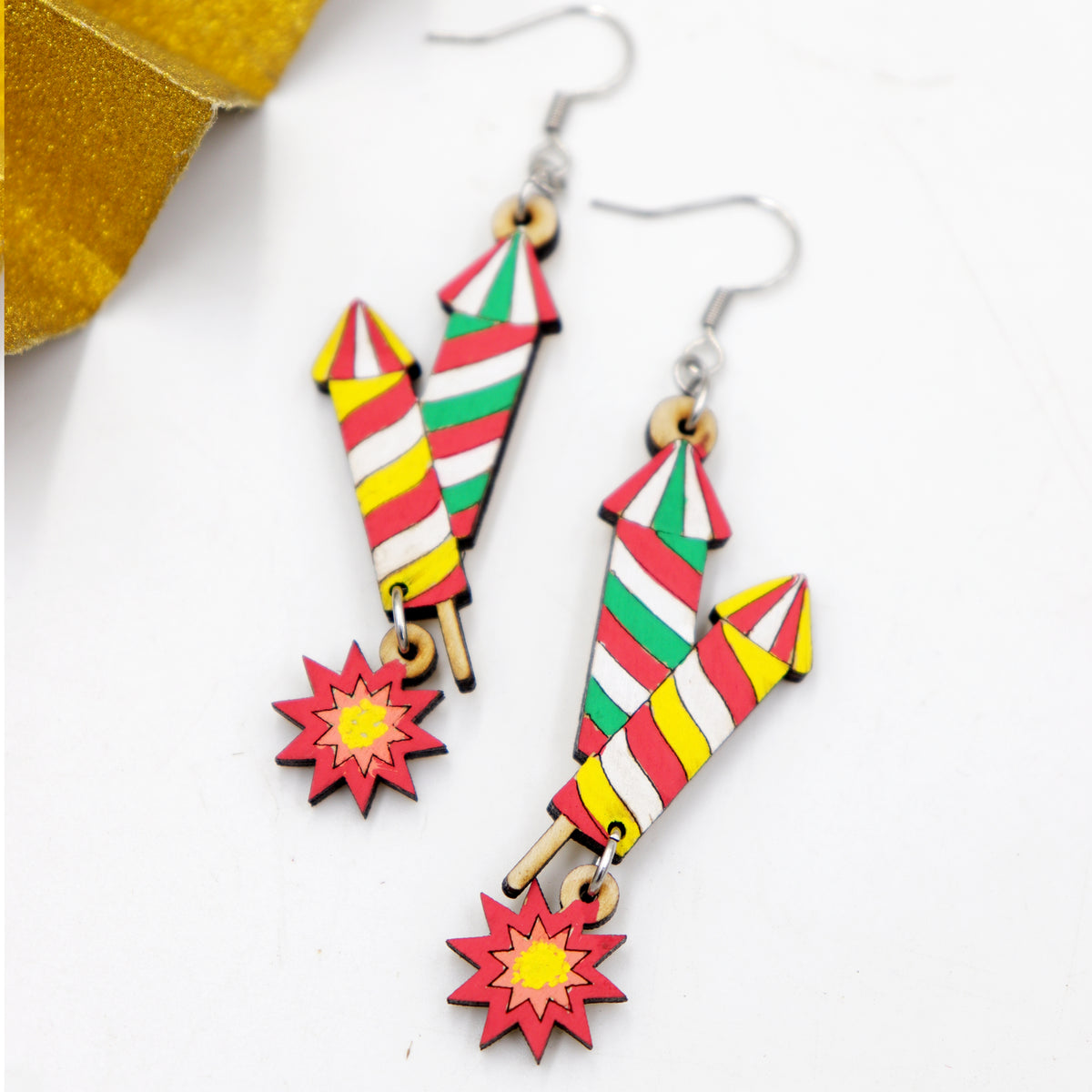 Hand-painted wooden Diwali double rocket firework dangle earrings with red, green and yellow stripes and starburst, handmade by Mekala Crafts