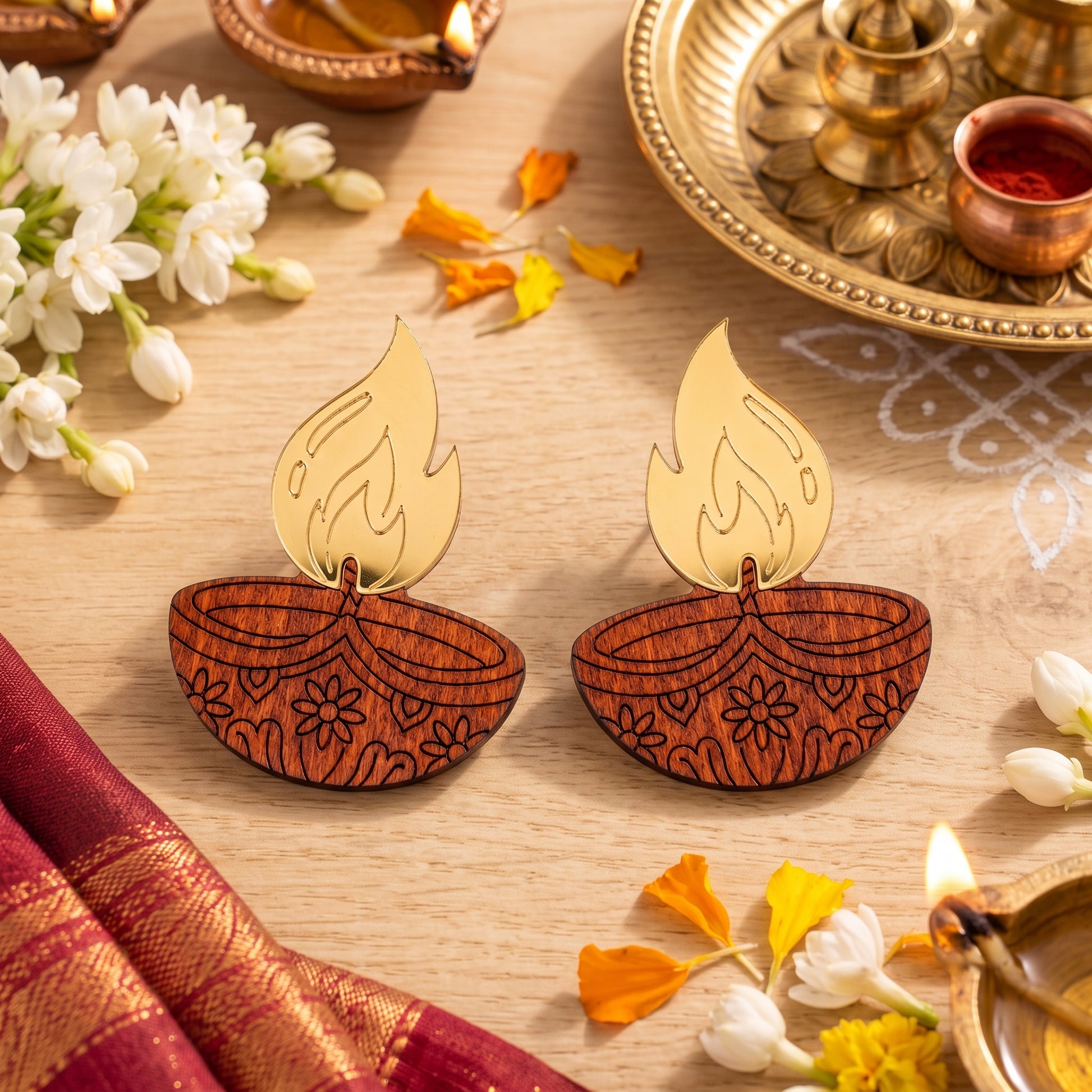 Close-up of wooden diya lamp earrings with gold acrylic flame and engraved floral pattern, handmade by Mekala Crafts